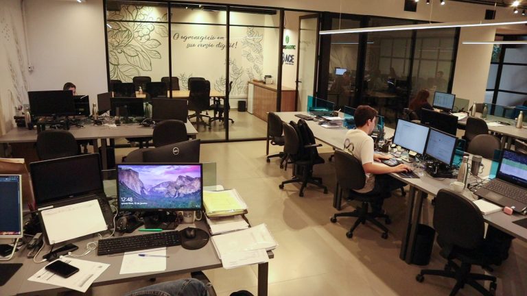 Estações de trabalho da Agromatic com sala de reunião envidraçada e murais do agro